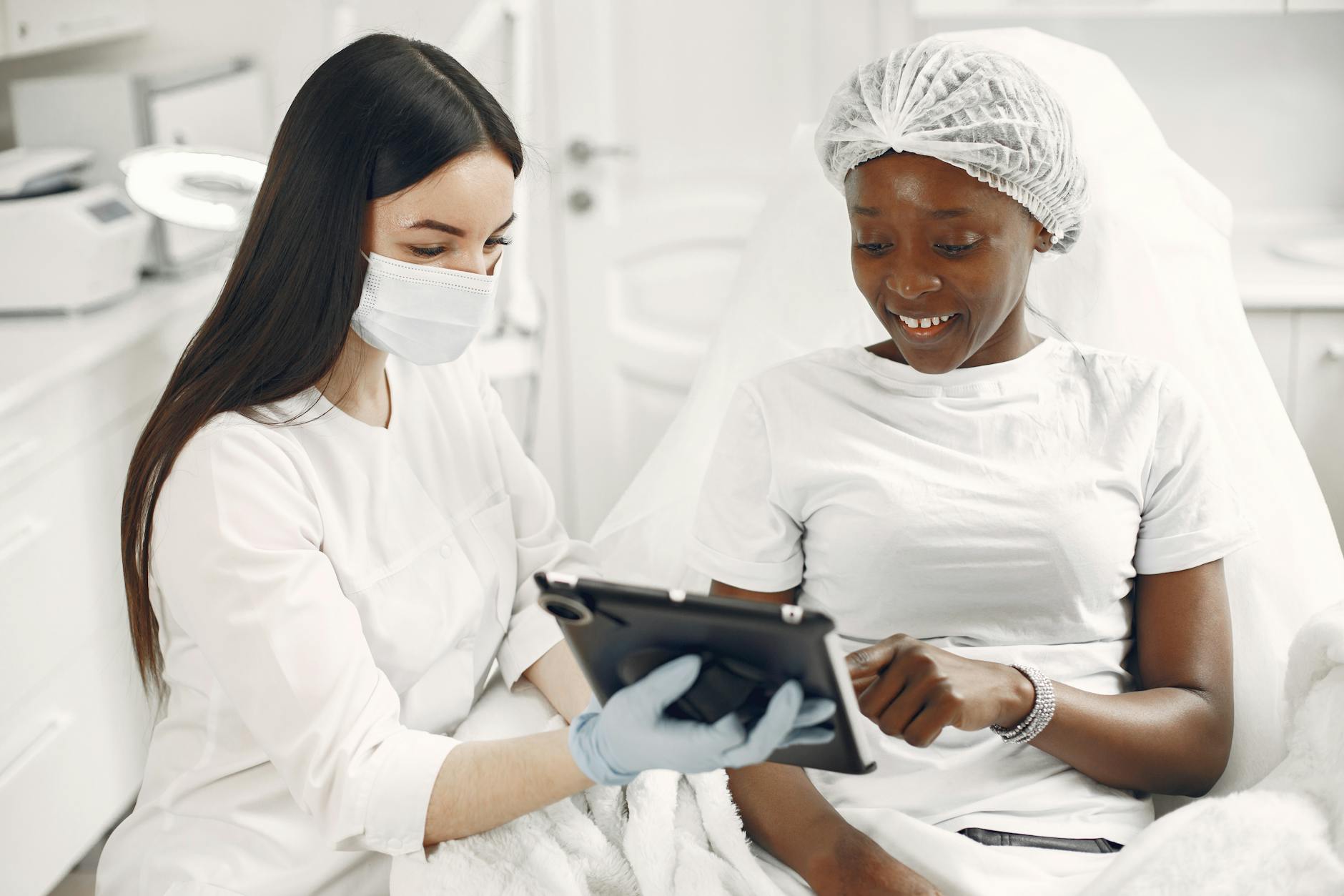 Dermatolog z pacjentką oglądają plan pielęgnacji skóry na tablecie