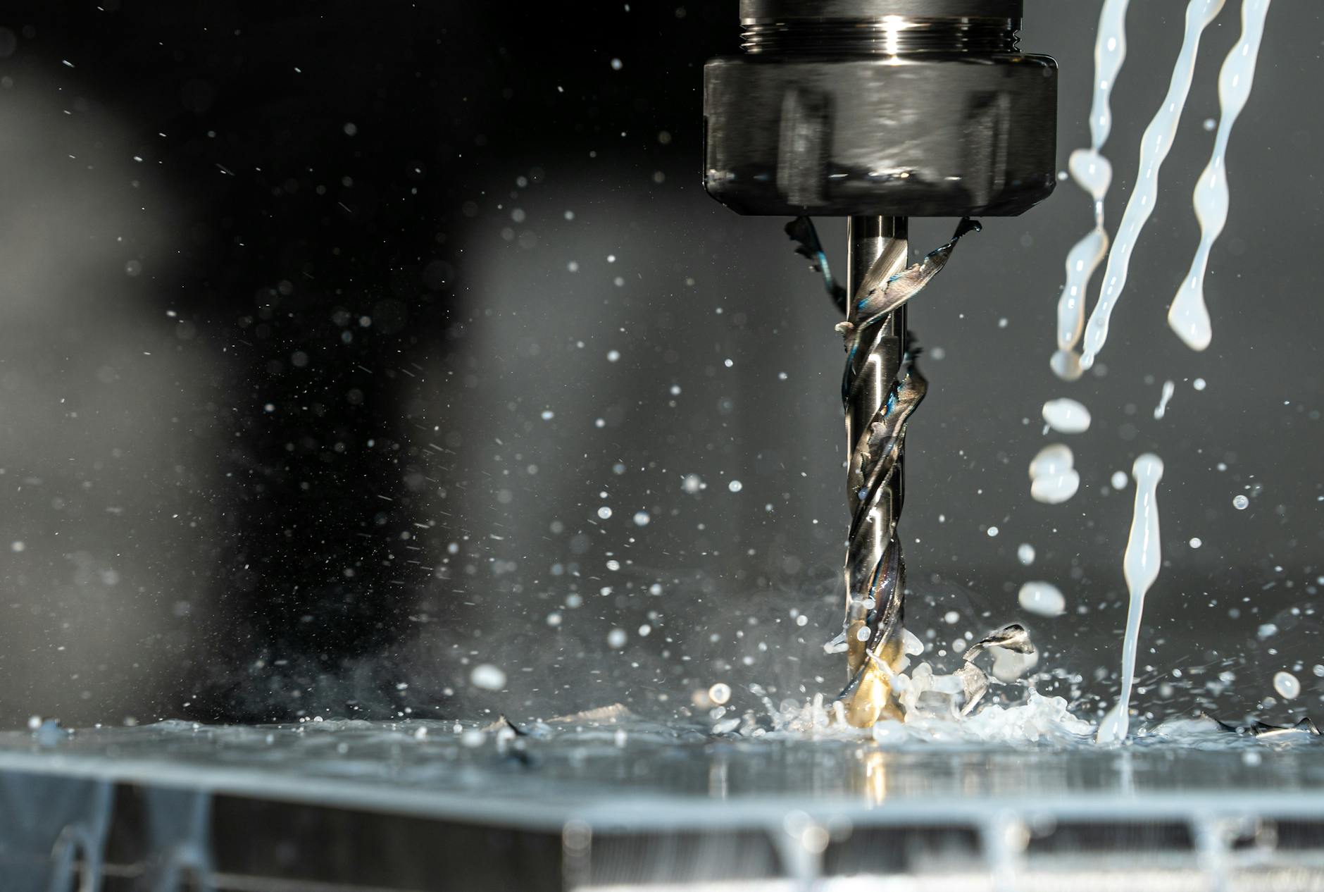 Minimalne smarowanie MQL: jakie narzędzia i geometrie działają najlepiej Wiertło CNC w ruchu z chłodziwem podczas obróbki skrawaniem