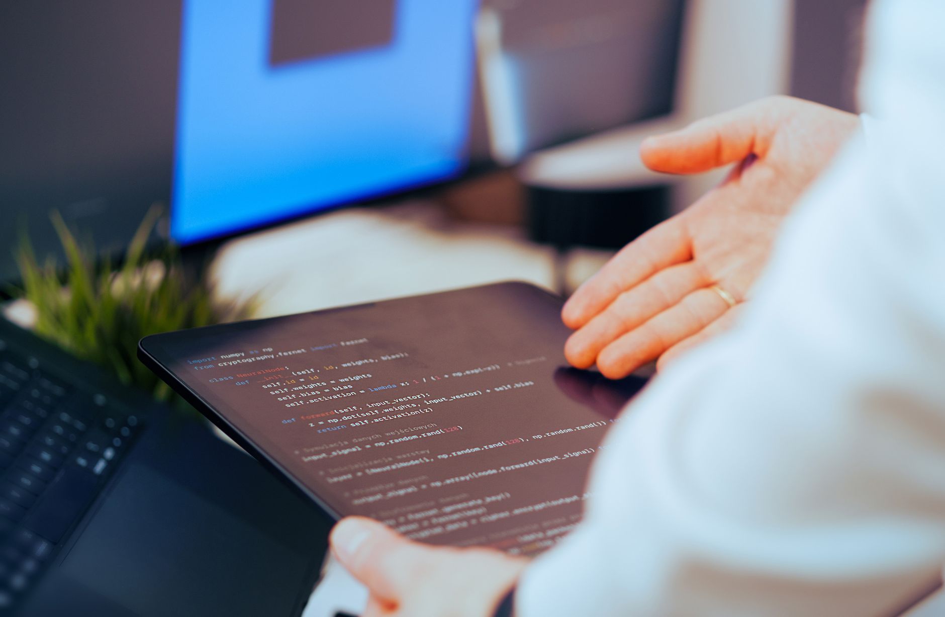 Programista analizujący kod na tablecie w nowoczesnym biurze