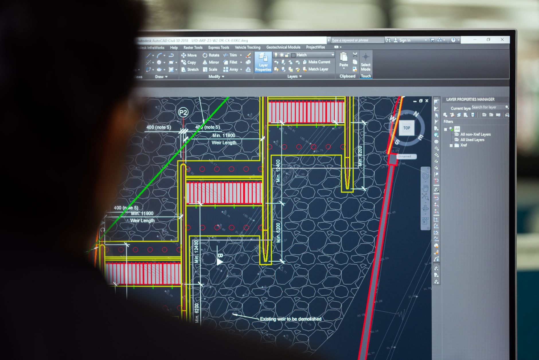 Inżynier projektujący jaz w programie CAD na monitorze w biurze