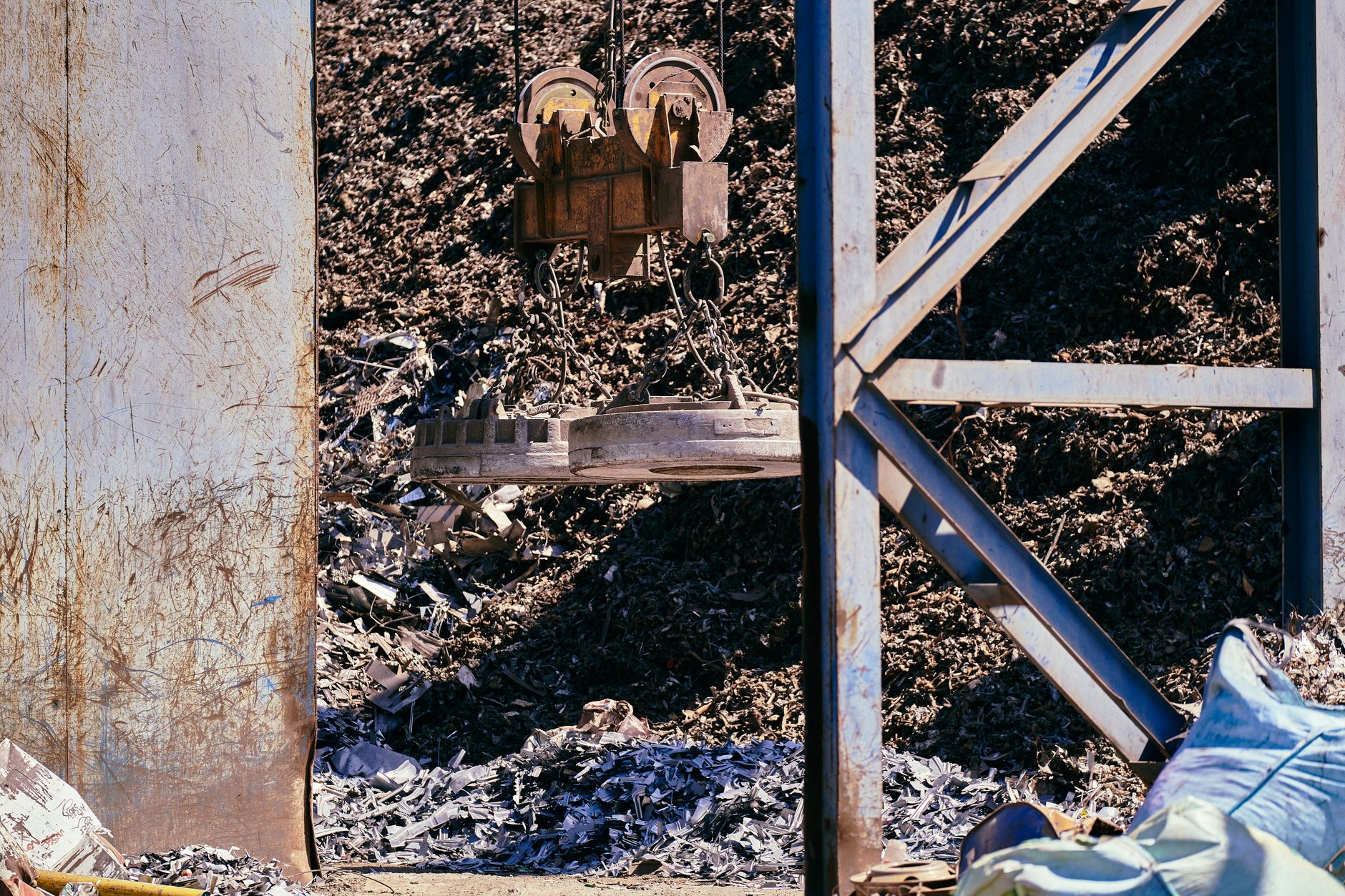 Magnetyczny dźwig sortuje złom metalowy na przemysłowym złomowisku